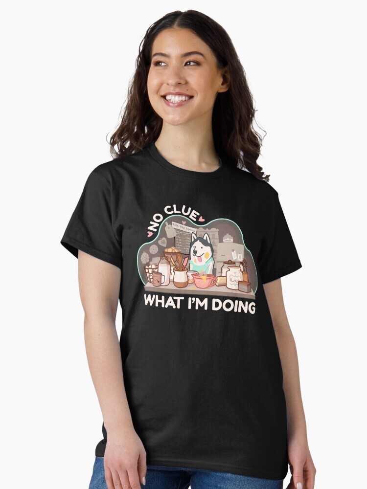 A brunette woman wearing a t-shirt  featuring a cartoon illustration with text saying 